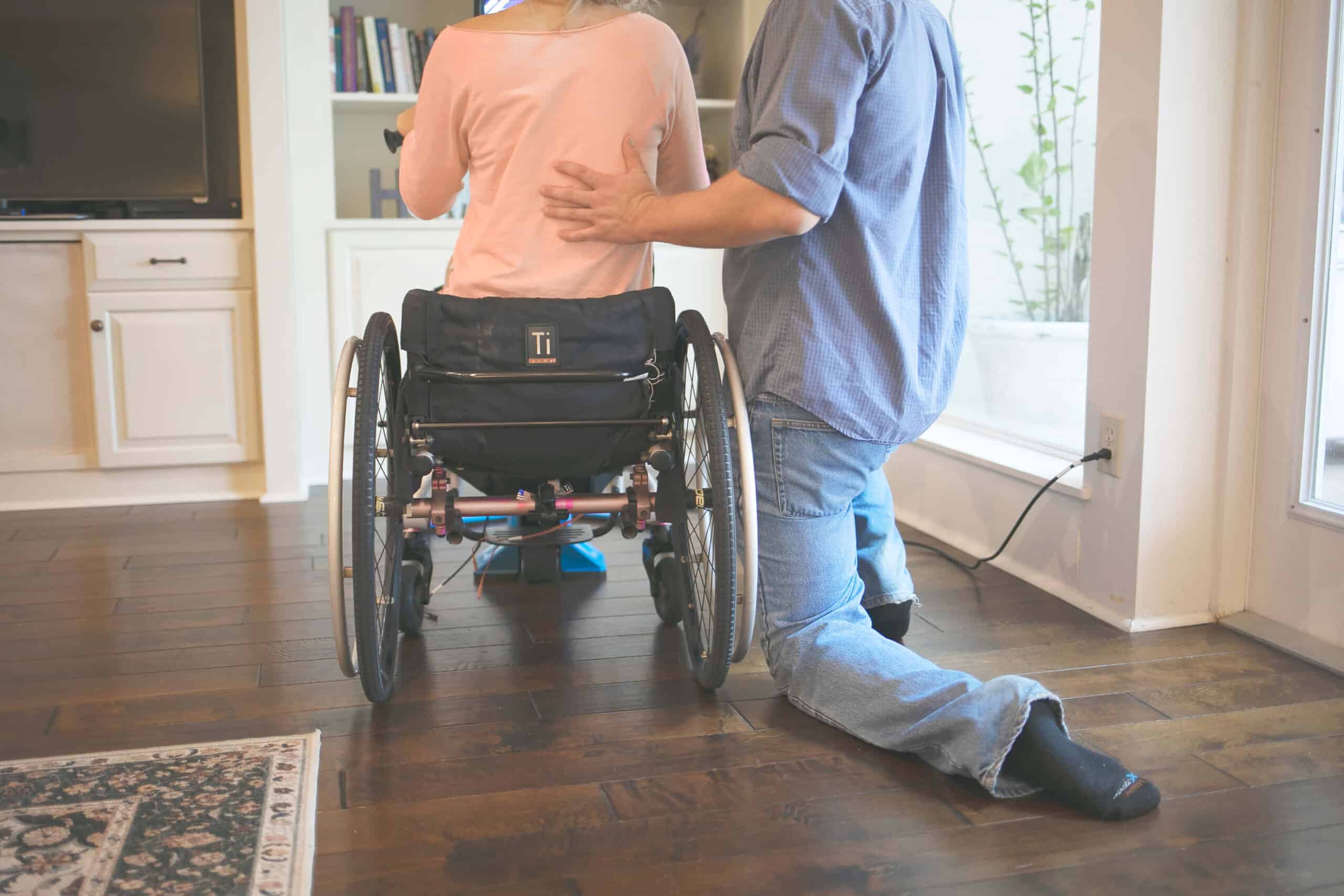 Aging with a spinal cord injury: a physical therapist helping someone in a wheelchair.