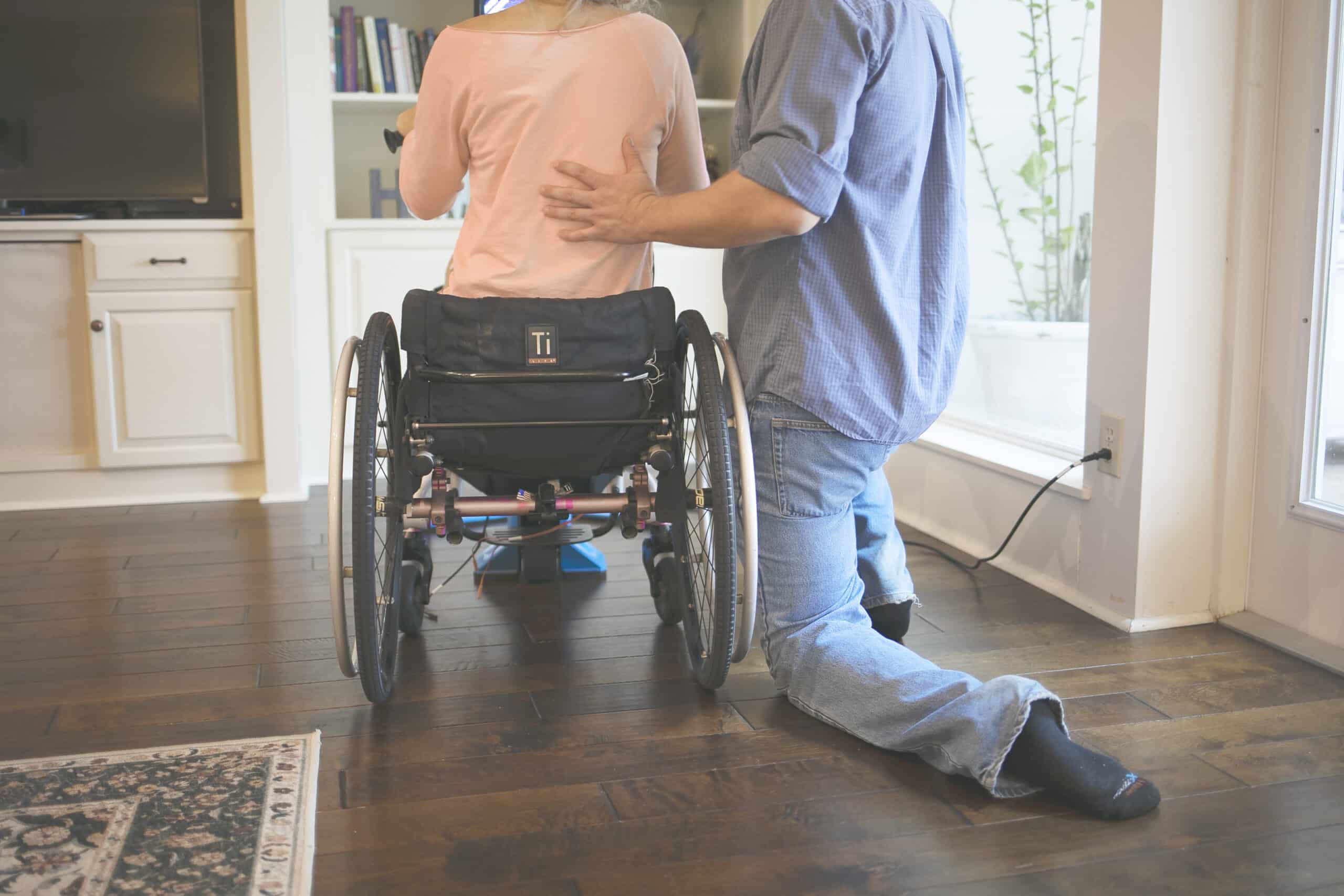 Incomplete spinal cord injury. A person in a wheelchair being assisted by a physical therapist.